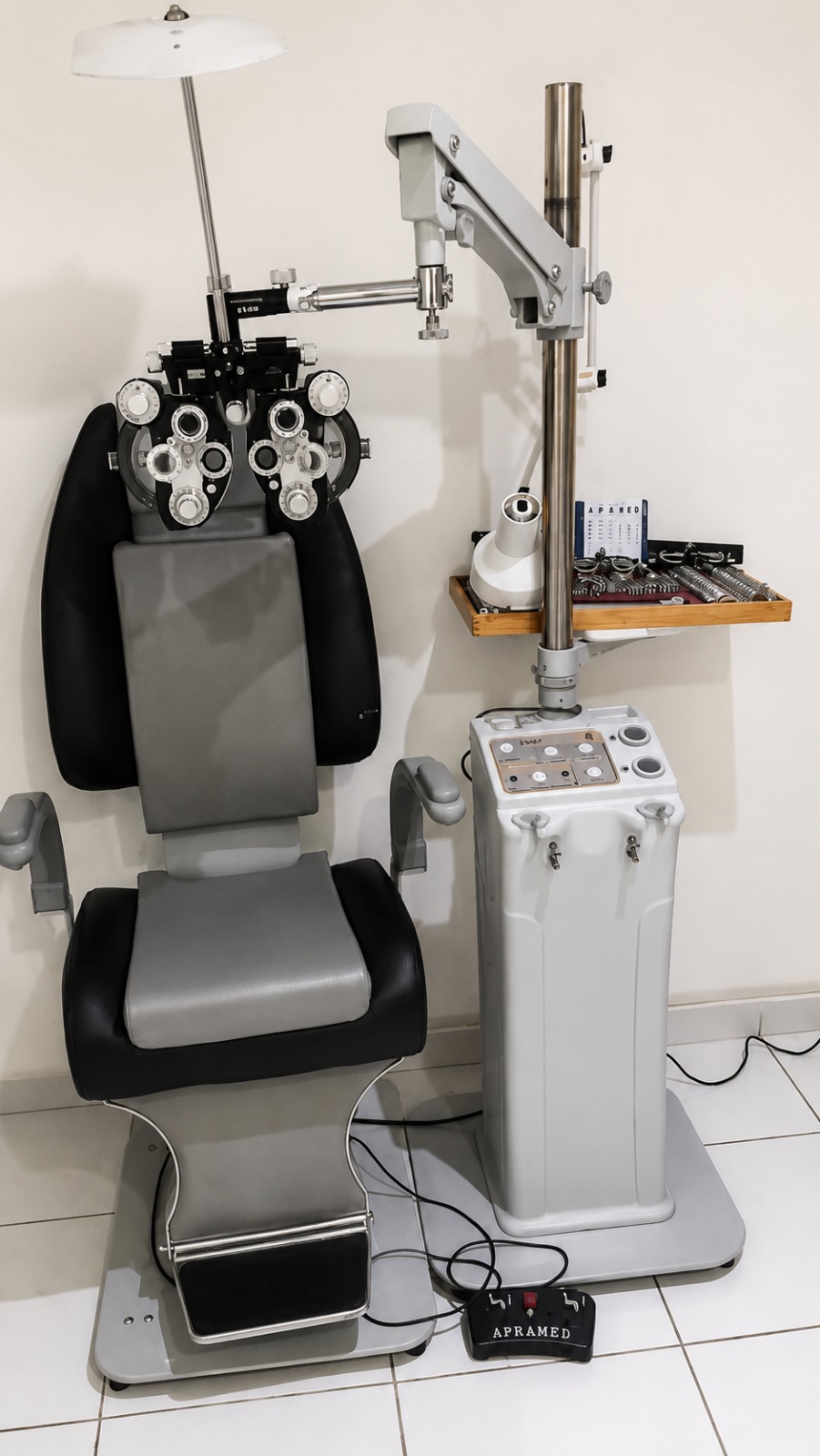 Sala de exame da clínica, com cadeira oftálmica, refrator e caixa de lentes de prova